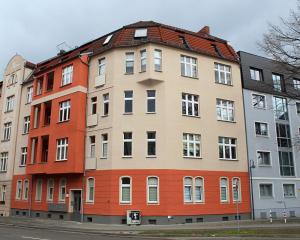 un bâtiment avec un toit rouge dans une rue dans l'établissement Lovely City-Apartment*Tiefgarage,Zentrum,BTU*, à Cottbus