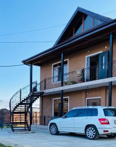 a white car parked in front of a building at Гостевой дом Александрия in Gudauta