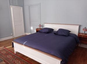 Un dormitorio con una cama grande con sábanas y almohadas púrpuras. en Château de Maucouvent, en Nevers