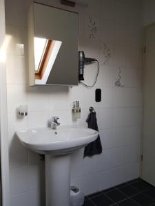 een badkamer met een witte wastafel en een spiegel bij Casa Blanca in Niestetal