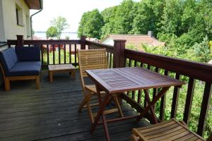 een houten terras met een houten tafel en stoelen bij Ferienwohnung mit Seeblick und Strand in Zislow