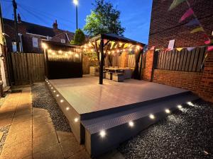 een patio met een tuinhuisje met verlichting bij Numero Uno Detached Aparthouse in Newcastle upon Tyne