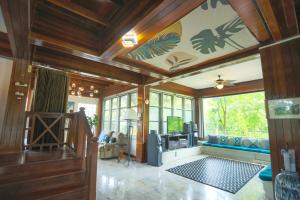 uma sala de estar com paredes de madeira e uma grande janela em Evergreen Pakchong Home em Pak Chong
