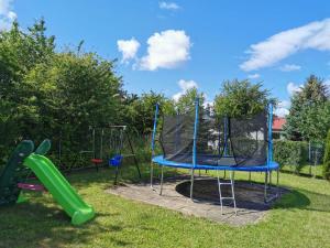 a playground with a trampoline in the grass at Dom Sonia in Niechorze