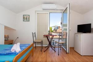 a bedroom with a bed and a table with chairs at Bogdanoski Studios & Guest Rooms in Ohrid