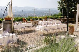 um grupo de mesas com linho branco e flores em Agriturismo I Millepini em Case Malva