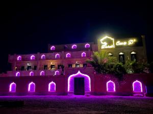 Casa d'Or Dahab PALAZZO في دهب: مبنى أمامه أضواء أرجوانية