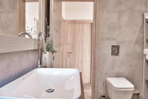 une salle de bain avec une baignoire blanche et des toilettes dans l'établissement Kidoni cottage, à Doukádes 33 autres photos