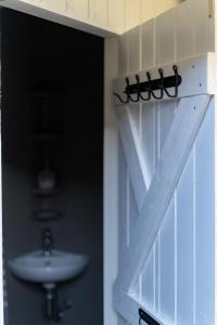 a bathroom door with a sink and a window at Jaukus mikro namas Svencelėje in Svenele