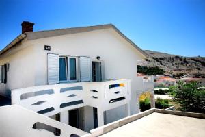 a white house with a balcony in front of it at The Peaceful Vacation in Metajna