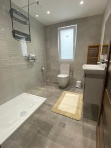 a bathroom with a tub and a toilet and a sink at Modern, Spacious, 3 Bedroom Apartment near Malta International Airport in Luqa