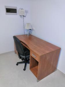 a wooden desk with a chair and a lamp at Modern, Spacious, 3 Bedroom Apartment near Malta International Airport in Luqa