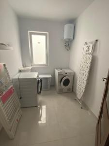 a bathroom with a washing machine and a washer and dryer at Modern, Spacious, 3 Bedroom Apartment near Malta International Airport in Luqa