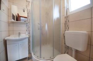 een badkamer met een douche, een toilet en een wastafel bij Apartments & Rooms Krecak Sibenik in Šibenik