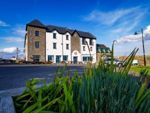 a large white building on the side of a street at Pier Head Hotel Spa & Leisure in Mullaghmore