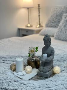 ein Tablett mit einer Buddha-Statue und Kerzen auf dem Bett in der Unterkunft Apartmány Ellie in Znojmo