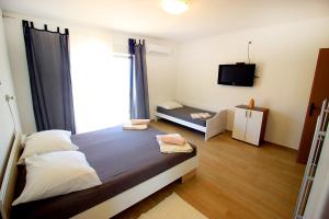 a bedroom with a large bed and a television at The Peaceful Vacation in Metajna