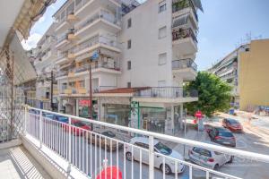 un balcone di un edificio con auto parcheggiate su una strada di SunRay City Apartment, Vesta Philoxenia a Salonicco