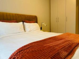 a large bed with white sheets and a brown blanket at Mikeys Place on Lever with Fibre Uncapped WiFi in Midrand