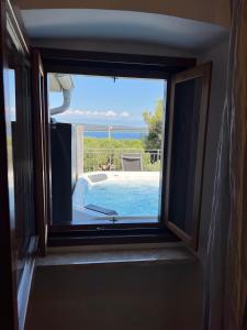a window view of a swimming pool and the ocean at Podgora Experience Suite with jacuzzi in Nerezine