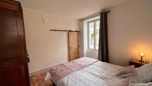 1 dormitorio con cama y ventana en Chez Loulou - La suite, en Lainsecq
