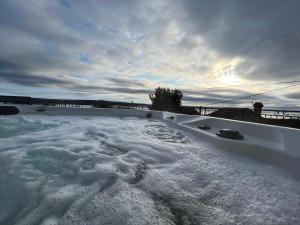 a hot tub covered in snow next to a fence at Podgora Experience Suite with jacuzzi in Nerezine