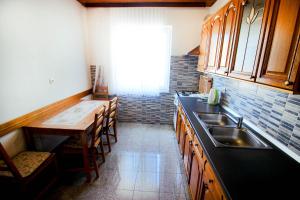 a kitchen with a sink and a table with chairs at The Peaceful Vacation in Metajna