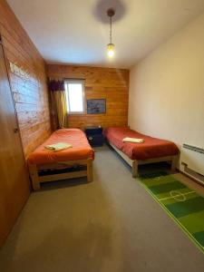 a room with two beds and a window in it at Departamento Valle Las Leñas in Las Lenas