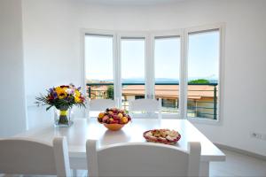 a white dining room with a white table and chairs at Casa di Mario in Golfo Aranci