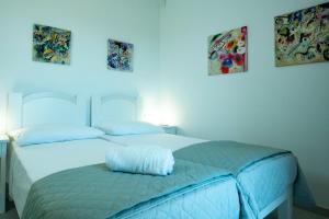 two beds in a bedroom with a blue light at Casa di Mario in Golfo Aranci