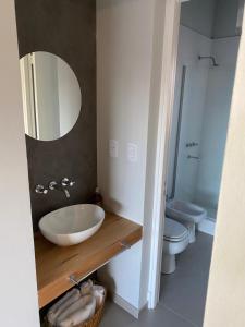 a bathroom with a sink and a toilet and a mirror at Moderno departamento ruta del vino en Bosques de Mayo in Maipú +8 photos