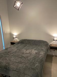 a bedroom with a bed and two lamps on two tables at Moderno departamento ruta del vino en Bosques de Mayo in Maipú