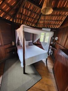 una camera mansardata con letto a baldacchino di The Spot - Beachfront Sports Pousada a Icaraí