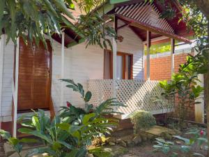 ein Haus mit Holztür und einigen Pflanzen in der Unterkunft Los Gavilanes Hotel in Pucallpa