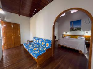 a bedroom with a bed and a chair and a mirror at Los Gavilanes Hotel in Pucallpa