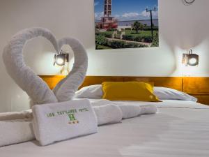 Una cama con dos toallas en forma de cisne. en Los Gavilanes Hotel, en Pucallpa