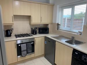 a kitchen with a sink and a stove top oven at Spacious and central 4-bedroom house with parking in Birmingham +15 photos
