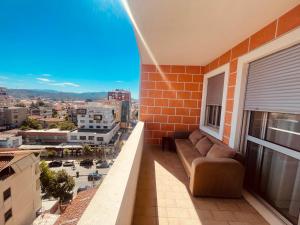 a balcony with a couch and a view of a city at Sky 2 Apartment City Center in Shkodër