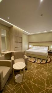 - une chambre avec un lit, un canapé et une table dans l'établissement وابل للوحدات السكنية, à Abha