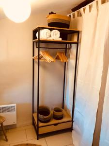 a shelf with bowls and baskets on it in a room at Appartement sur le toit avec terrasse et belle vue in Roujan