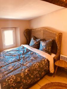 um quarto com uma cama com um cobertor azul em Appartement sur le toit avec terrasse et belle vue em Roujan