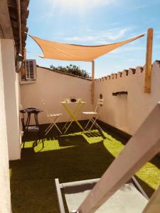 a patio with a table and chairs on a wall at Appartement sur le toit avec terrasse et belle vue in Roujan