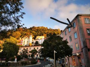 une rue urbaine avec des bâtiments et une colline en arrière-plan dans l'établissement Sintra Design Apartment_Palácio da Pena, à Sintra