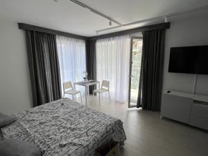 a bedroom with a bed and a table with chairs at Srebrna Perła 2-3 os in Sienna