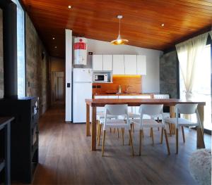 eine Küche mit einem Holztisch und weißen Geräten in der Unterkunft Casa Puerto del aguila, Sierras de Cordoba, los molinos in Potrero de Garay
