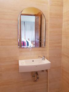 une salle de bain avec un lavabo et un miroir dans l'établissement Atuh Galaxy Cottage, à Nusa Penida