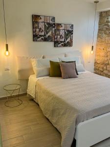 a bedroom with a large white bed with pillows at La Pelliccia in Bari