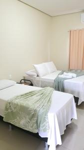 drie bedden in een kamer met witte muren bij apartamento 2 da Cintia in Lençóis