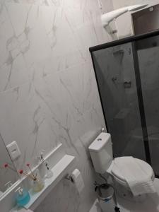 a white bathroom with a toilet and a shower at apartamento 2 da Cintia in Lençóis +8 photos
