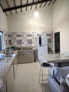 a kitchen with granite counter tops and a refrigerator at apartamento 2 da Cintia in Lençóis